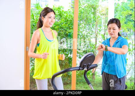 Madre e figlia che si allenano con la macchina a casa propria Foto Stock