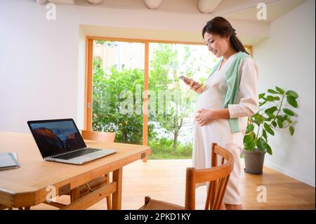 Donne incinte che lavorano in telelavoro Foto Stock