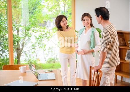 Le donne incinte e i loro genitori che lavorano in telelavoro Foto Stock