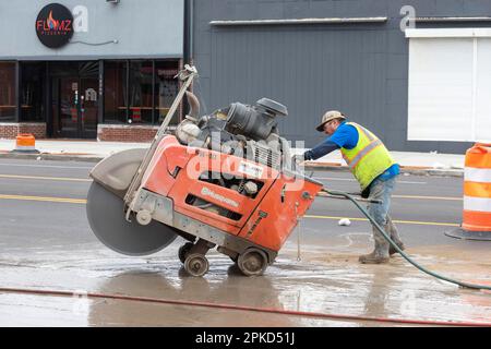 Detroit, Michigan, Un operaio gestisce una sega in cemento a piedi come parte di un progetto per creare piste ciclabili protette, marciapiedi più ampi e per lo stabilimento Foto Stock