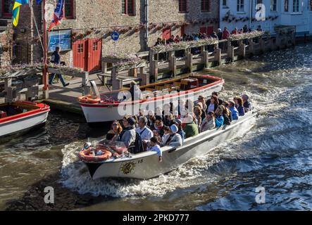 Tourist godendo di una gita in barca intorno a Bruges Fiandre Occidentali in Belgio Foto Stock