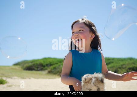 Ragazza ridendo in bolle di sapone Foto Stock