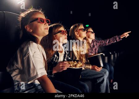 Interessante film. Gruppo di bambini seduti al cinema Foto Stock