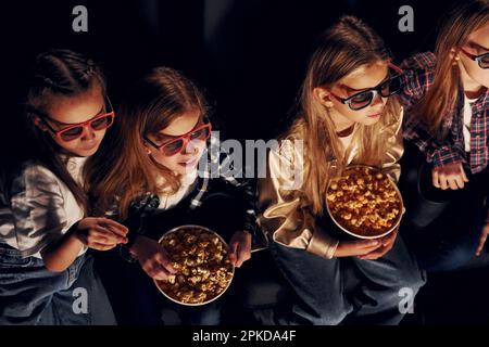 Amici che guardano film insieme. Gruppo di bambini seduti al cinema Foto Stock