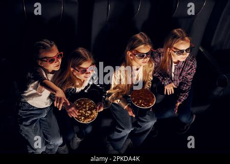 Amici che guardano film insieme. Gruppo di bambini seduti al cinema Foto Stock