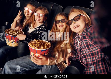 Gruppo di bambini seduti al cinema e che guardano un film insieme Foto Stock