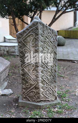 Zvorrnik, Bosnia-Erzegovina – Febbraio 2023: Pietre lapidi Stecak-medievali di fronte alla biblioteca. Foto Stock