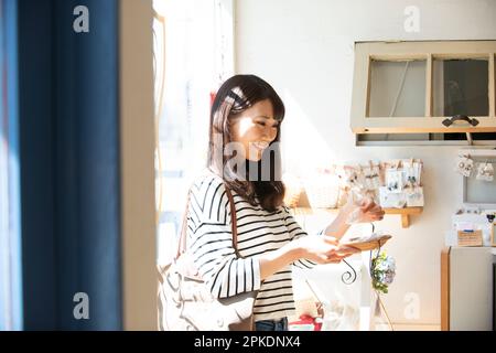 Donna che seleziona i prodotti in un negozio di alimentari Foto Stock