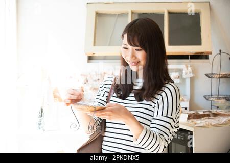 Donna che seleziona i prodotti in un negozio di alimentari Foto Stock