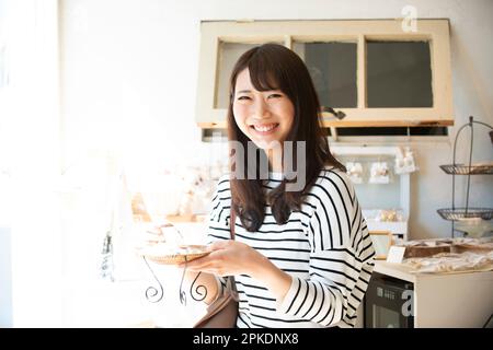 Donna che seleziona le merci in un negozio di alimentari Foto Stock