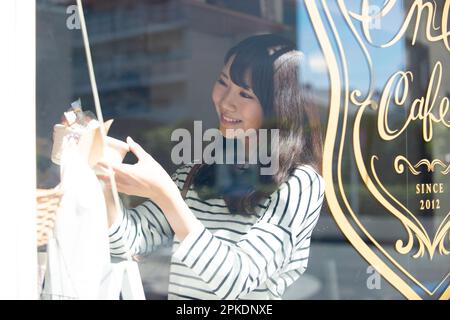 Donna che seleziona gli accessori in un negozio di alimentari Foto Stock