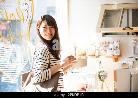 Donna che seleziona gli accessori in un negozio di alimentari Foto Stock