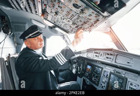 Un pilota professionista è nel cockpit. Concezione del lavoro Foto Stock