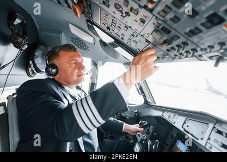 Vista laterale. Un pilota professionista è nel cockpit. Concezione del lavoro. Foto Stock