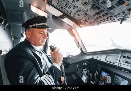 Un pilota professionista è nel cockpit. Concezione del lavoro Foto Stock