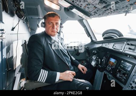 Vista laterale. Un pilota professionista è nel cockpit. Concezione del lavoro. Foto Stock