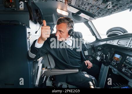 Vista laterale. Un pilota professionista è nel cockpit. Concezione del lavoro. Foto Stock