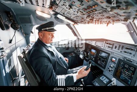 Vista laterale. Un pilota professionista è nel cockpit. Concezione del lavoro. Foto Stock