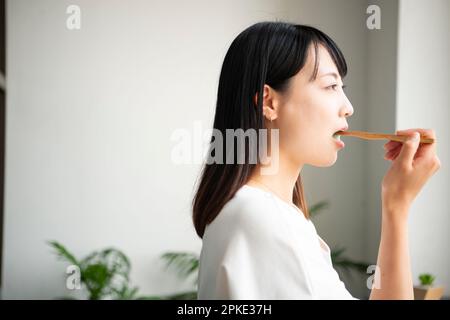 Donna spazzolare i suoi denti Foto Stock