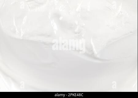 Primo piano della superficie bianca in crema cosmetica come trama o sfondo, vista dall'alto Foto Stock