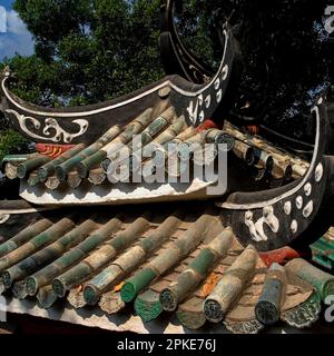 Graziosi vagli volanti decorati in nero e bianco curvano verso l'alto su creste di piastrelle di ceramica semicircolare verde su un tipico tetto tradizionale sopra un padiglione del Tempio A-ma a Macau, Cina. Il tempio, risalente al 1488 d.C., sorge dove A-ma o Tin Hau, madre-dea taoista e protettrice dei marinai, sbarcò in modo sicuro in una barca da pesca dopo una tempesta prima di ascendere al cielo. Foto Stock