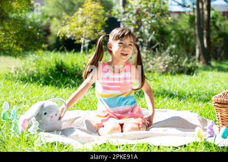 Ragazza seduta sull'erba ridendo Foto Stock