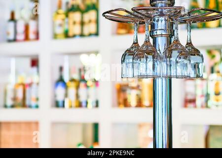 Bicchieri da vino appesi al banco del bar in una caffetteria o in un ristorante Foto Stock