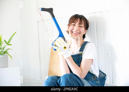 Donna che ride con un hacksaw Foto Stock