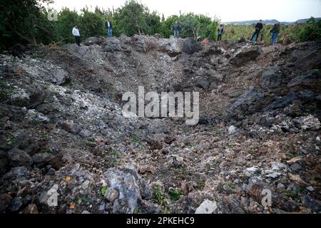 Beirut, Libano. 7th Apr, 2023. I libanesi ispezionano il sito degli attacchi aerei israeliani sulle terre agricole vicino alla città di Tiro, Libano meridionale, 7 aprile 2023. Forti esplosioni sono state sentite all'inizio di venerdì mattina intorno alla città libanese di Tiro subito dopo che le forze di difesa israeliane hanno informato la forza ad interim delle Nazioni Unite in Libano (UNIFIL) che avrebbero iniziato una risposta di artiglieria ai lanci di razzi dal sud del Libano, ha detto l'attrezzatura di mantenimento della pace delle Nazioni Unite in una dichiarazione di stampa. Credit: Ali Hashisho/Xinhua/Alamy Live News Foto Stock