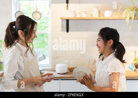 Piatti di pulizia per madre e figlia Foto Stock