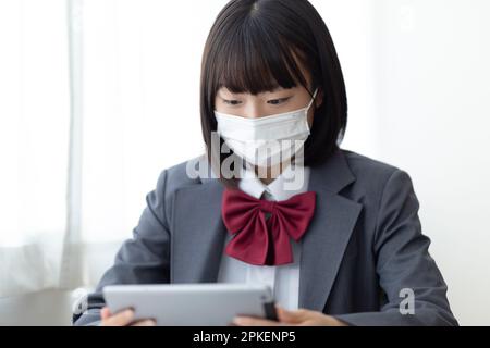 Ragazze della scuola superiore che indossano maschere in classe Foto Stock