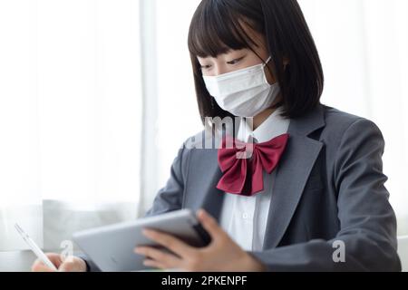 Ragazze della scuola superiore che indossano maschere in classe Foto Stock
