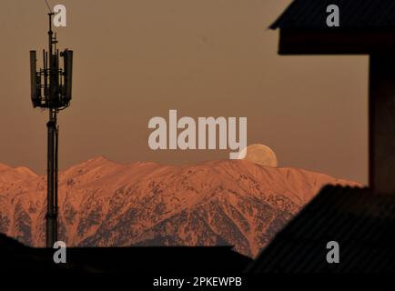 Srinagar, India. 07th Apr, 2023. La luna piena si trova sopra la catena montuosa dell'Himalaya coperta dalla neve, il Kashmir, il captiale estivo del Kashmir amministrato dagli indiani, il 7 aprile 2023. La luna piena di aprile è anche conosciuta come rosa, uovo e luna di pesce. (Foto di Mubashir Hassan/Pacific Press) Credit: Pacific Press Media Production Corp./Alamy Live News Foto Stock