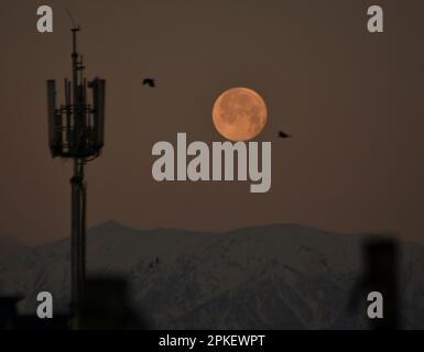 Srinagar, India. 07th Apr, 2023. La luna piena si trova sopra la catena montuosa dell'Himalaya coperta dalla neve, il Kashmir, il captiale estivo del Kashmir amministrato dagli indiani, il 7 aprile 2023. La luna piena di aprile è anche conosciuta come rosa, uovo e luna di pesce. (Foto di Mubashir Hassan/Pacific Press) Credit: Pacific Press Media Production Corp./Alamy Live News Foto Stock