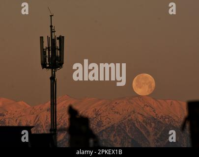 Srinagar, India. 07th Apr, 2023. La luna piena si trova sopra la catena montuosa dell'Himalaya coperta dalla neve, il Kashmir, il captiale estivo del Kashmir amministrato dagli indiani, il 7 aprile 2023. La luna piena di aprile è anche conosciuta come rosa, uovo e luna di pesce. (Foto di Mubashir Hassan/Pacific Press) Credit: Pacific Press Media Production Corp./Alamy Live News Foto Stock