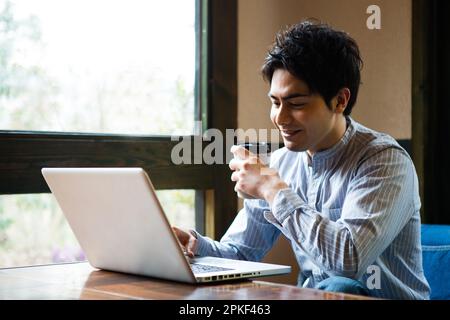 Uomini che usano i computer in un bar Foto Stock
