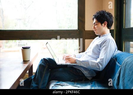 Uomini che usano i computer in un bar Foto Stock