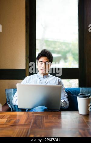 Uomini che usano i computer in un bar Foto Stock