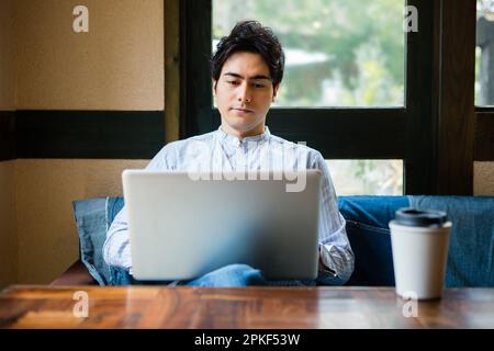 Uomini che usano i computer in un bar Foto Stock