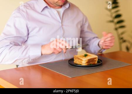 Primo piano dell'uomo che mangia un panino. Foto Stock