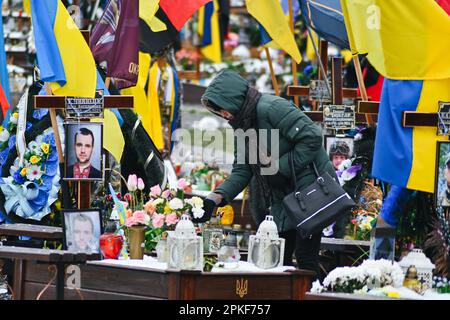 7 aprile 2023, Lviv, regione di Lviv, Ucraina: Una donna si ricorda su una tomba. Al cimitero di Lychakiv, nella parte sud-orientale di Lviv, Ucraina occidentale, il 7 aprile 2023. Il cimitero di Lychakiv è dove sono sepolti i corpi di centinaia di soldati ucraini morti in combattimento. I parenti dei defunti vengono a visitare le loro tombe poche settimane prima della Pasqua ortodossa, celebrata il 24 aprile in Ucraina. (Credit Image: © Adrien Fillon/ZUMA Press Wire) SOLO PER USO EDITORIALE! Non per USO commerciale! Foto Stock