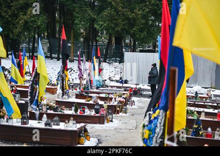 7 aprile 2023, Lviv, regione di Lviv, Ucraina: Una donna si ricorda su una tomba. Al cimitero di Lychakiv, nella parte sud-orientale di Lviv, Ucraina occidentale, il 7 aprile 2023. Il cimitero di Lychakiv è dove sono sepolti i corpi di centinaia di soldati ucraini morti in combattimento. I parenti dei defunti vengono a visitare le loro tombe poche settimane prima della Pasqua ortodossa, celebrata il 24 aprile in Ucraina. (Credit Image: © Adrien Fillon/ZUMA Press Wire) SOLO PER USO EDITORIALE! Non per USO commerciale! Foto Stock