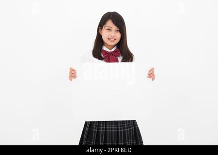 Studente di scuola superiore che tiene una lavagna bianca Foto Stock