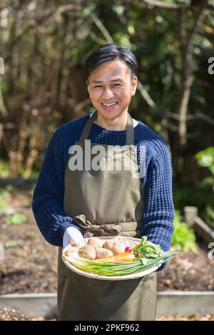 Uomo che tiene verdure dal campo Foto Stock