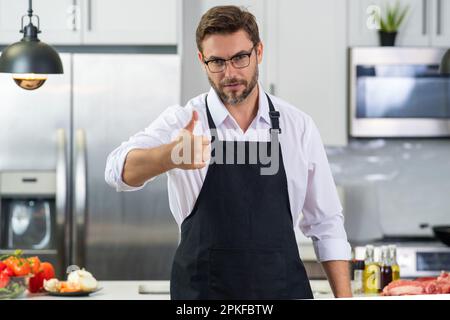 Uomo in cuoco grembiule cucina Foto stock - Alamy