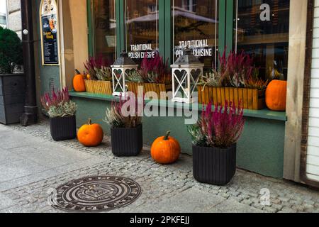 Danzica, Polonia - 30 ottobre 2022: Decorazione zucche all'aperto caffè in strada città, festive decorazioni negozi ed edifici. Halloween festivo Foto Stock