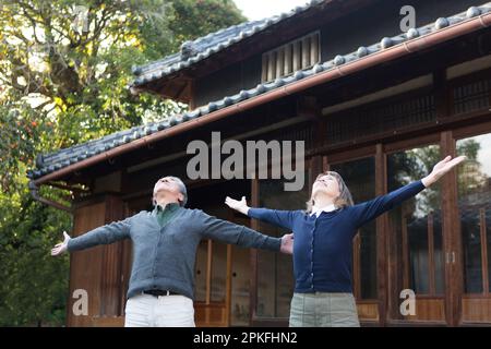 Una coppia anziana che si esercita di fronte alla loro casa di campagna Foto Stock