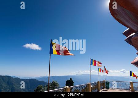 Le bandiere colorate della preghiera buddista stanno sventolando sotto il sole a Samdruptse, enorme monastero commemorativo buddista a Sikkim, India. Foto Stock