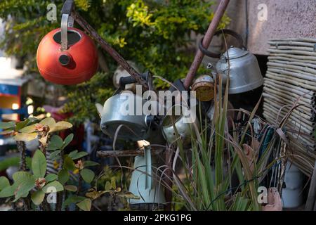 I teapots arrugginiti riproposti: Decorazione sostenibile del giardino per un domani più verde in un giorno soleggiato, incarnando il riutilizzo e il fascino rustico. Foto Stock