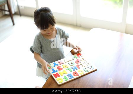 Ragazza che fa puzzle alfabeto Foto Stock